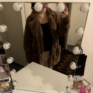 Brun teddyjacka - Mysig brun teddyjacka i oversized stil. Perfekt för kalla höst- och vinterdagar. Jackan har långa ärmar och stora fickor framtill. Den är supermjuk och håller dig varm och bekväm hela dagen. Ett måste för garderoben!