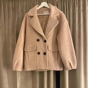 Beige teddyjacka från Mako - Säljer en supermysig beige teddyjacka från Mako. Den har en oversized passform med stora knappar och två fickor fram. Perfekt för höst och vinter när du vill hålla dig varm och stilren. Jackan är i mycket bra skick och redo för nya äventyr!