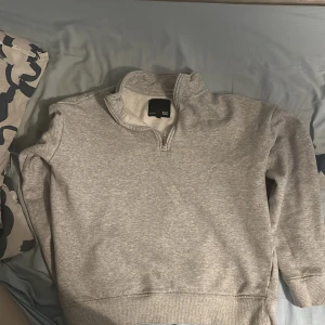 Grå tröja med dragkedja - Säljer en stilren grå tröja från 157 i storlek S. Den har en praktisk dragkedja vid halsen och är perfekt för både vardag och avslappnade tillfällen. Tröjan är i bra skick och gjord av mjukt material för extra komfort.