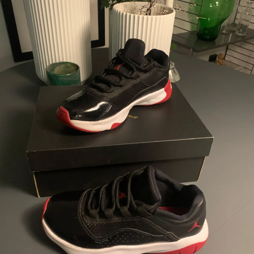 Säljer ett par snygga Nike Air Jordans i svart och rött. Skorna är i nytt skick och har en cool design med snörning. Perfekta för både vardag och fest! De kommer i originalkartong. Nypris 1899kr ~ mitt pris 1299kr🤩🤩PRIS GÅR ATT DISKUTERA!. Skor.