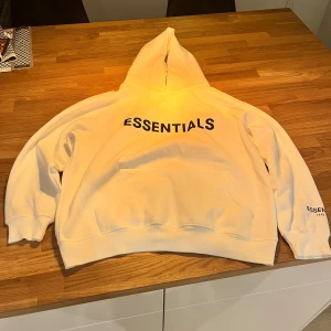 Vit hoodie från Essentials - Säljer en snygg vit hoodie från Essentials. Den är aldrig andvänd och har en oversized passform perfekt för höst! Kommer i originalförpackning. Kan vara flexibel om pris vid snabb affär