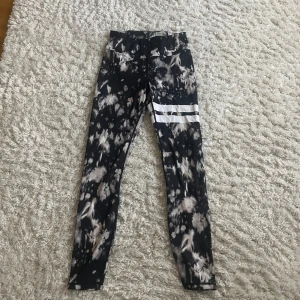 Mönstrade leggings från Stronger - Säljer ett par snygga leggings från Stronger i storlek S. De har ett coolt svart och grått mönster med vita ränder på ena benet. Perfekta för träning eller en avslappnad dag. Superbekväma och stretchiga! Helt nya säljer pga inte min storlek 