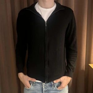 Svart kofta med dragkedja från Sand - Säljer en stilren svart kofta med dragkedja framtill. Den har långa ärmar och en bekväm passform. Passar bra till jeans eller chinos. Ett måste i garderoben för höst och vinter! Skick 7/10. Den har råkats krympa en gång i tvätten och och sitter nu som en xs/s. Nypris 2400. Tveka inte på att höra av dig vid frågor/intresse💫