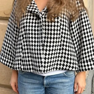 Svartvit rutig kappa - Säljer en superfin svartvit rutig kappa med stora knappar och trekvartsärm. Perfekt för höst och vår! Den har en chic och elegant stil som passar både till vardags och fest. Kappan är i mycket bra skick och ger en klassisk look. Sitter som M😍😍😍