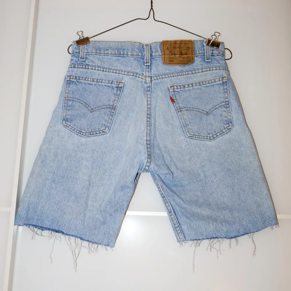 Säljer ett par ljusblå jeansshorts från Levi's i bra skick. De är högmidjade och har en klassisk femficksdesign. Shortsen har en rå kant nertill för en avslappnad look. Perfekta för sommardagar eller festivaler! 🕶️. Shorts.