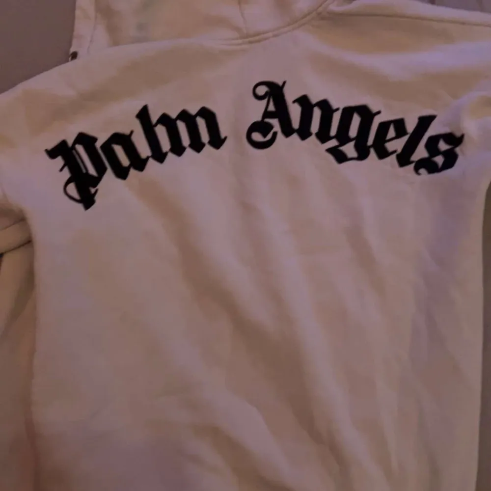 Säljer en snygg hoodie från Palm Angels. Den har en stor logga på ryggen och en mindre på bröstet. Perfekt för en casual look och superbekväm att ha på sig. Passar både till vardags och chillkvällar. 🧥✨. Tröjor & Koftor.