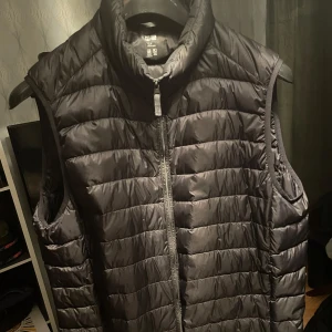 Uniqlo Väst - Svart lätt dunväst från Uniqlo i storlek L men skulle mer säga att den är som en M! Gott skick!En väldigt bekväm och stilren väst som passar till nästan allt🔥Vid funderingar så är det bara att skriva/ Karl!