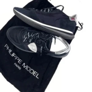 Svarta sneakers från Philippe Model - Säljer ett par snygga svarta sneakers från Philippe Model. De har en stilren design med snörning och en bekväm sula. Perfekta för både vardag och fest. Skorna är i bra skick och kommer med originalpåse.