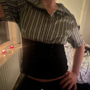 Randig skjorta med korta ärmar - Säljer en stilren randig skjorta med korta ärmar. Perfekt för både vardag och fest! Skjortan har en klassisk krage och knappar framtill. Den är i bra skick och passar perfekt till jeans eller kostymbyxor.