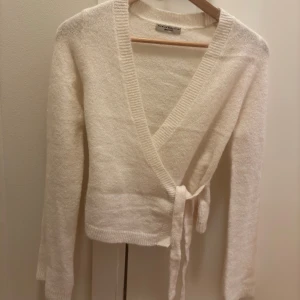 Vit omlottkofta från Gina Tricot - Jättefin omlottkofta från Gina😍tyvärr passar den inte på mig. Aldrig använd,nyskick. Nypris 400kr