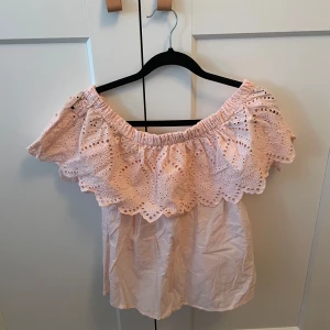 Rosa offshoulder topp från Gina Tricot - Säljer en söt rosa offshoulder topp från Gina Tricot. Toppen har vackra spetsdetaljer och en luftig passform. Perfekt för varma sommardagar🩷 Se bild 4 för hur det ser ut under armarna. Använd ett fåtal gånger. Köpare står för frakten!