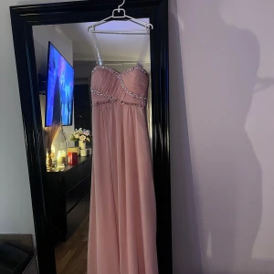 Balklänning - Perfekt balklänning, är storlek 6 på den, vet inte riktigt vilken storlek det är men brukar vanligtvis ha S o den passar på mig. Är 165 o på mig går den ner över fötterna därför perfekt att ha lite klack till. Den är stretchig över bysten vilket gör att den inte sitter åt konstigt. Sitter som en gummikant längst upp men jag har även valt att köpa till två genomskinliga axelband till den för lite extra lyft. 