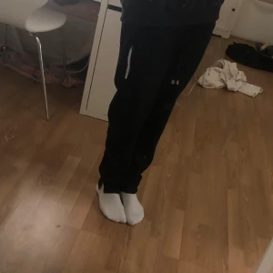 Svarta mjukisbyxor med snörning - Säljer ett par svarta mjukisbyxor med snörning i midjan. Byxorna har en avslappnad passform och är perfekta för en bekväm dag hemma. De är tillverkade i ett mjukt material som känns skönt mot huden.