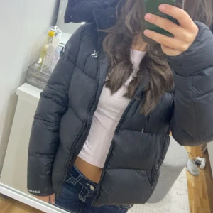 Ck jacka  - Snygg svart pufferjacka från Calvin Klein med dragkedja och hög krage. Perfekt för kyliga dagar. Jackan har en stilren design med CK-logga på bröstet. Mycket bra skick!! Skriv för fler bilder! Pris kan diskuteras💕