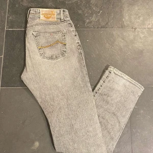 Grå jeans från Jacob Cohën - Snygga sällsynta grå jeans från Jacob Cohën med klassisk femficksdesign och guldfärgad söm på bakfickan. Perfekt för en stilren look. Midjan är normal och passformen är straight, vilket ger en bekväm känsla. Priset är ej hugget i sten!!!
