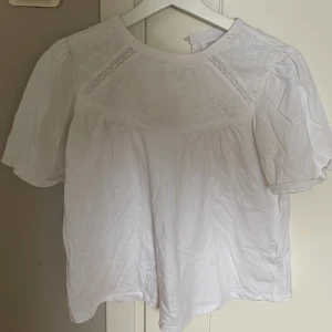Vit blus från Zara - Säljer en söt vit blus från Zara med korta puffärmar och fina spetsdetaljer vid halsen. SKRIV TILL MIG INNAN NI KLICKAR PÅ KÖP!! 💞💞