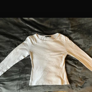 Vit långärmad topp från 157 - Säljer en stilren vit långärmad topp från 157. Perfekt för en enkel och klassisk look. Toppen är i en mjuk och bekväm bomullskvalitet.