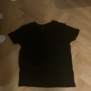 Svart t-shirt  - Säljer en klassisk svart t-shirt . Perfekt basplagg med korta ärmar och normal passform. Passar till alla tillfällen och är lätt att matcha med andra kläder.