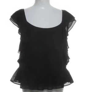 Gullig svart volangblus från Twist & Tango - Fin svart volangblus från Twist & Tango. Blusen har en rund halsringning och volanger runt armen
