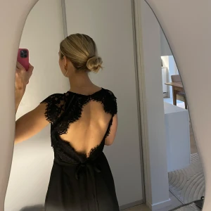 Balklänning svart - Säljer denna slutsålda balklänning med öppen rygg från Nelly. Klänningen har ett band i midjan som går att knyta båda fram och bak (se bild 1 och 4). För referens är jag 165cm och har 8cm klackar på bilden. Lägg gärna bud eller hör av er för fler bilder!💞