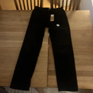 Svarta byxor 'Staffan' med rak passform - Snygga svarta byxor med rak passform och normal midja. Modellen 'Staffan' har en borstad insida för extra komfort. Tillverkade med vatten- och energibesparande processer.