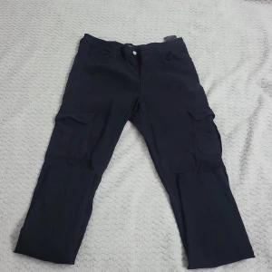 Svarta cargopants - Snygga svarta cargopants med flera praktiska fickor. Perfekta för en avslappnad stil. Byxorna har en rak passform och är tillverkade i ett slitstarkt material.