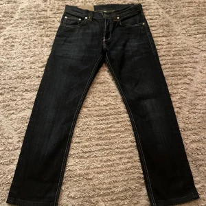 Dondup Jeans - Säljer dessa snygga Dondup jeans i en klassisk mörkblå färg! Skick 9/10. Modell MUSIC. Modellen är 174 och väger 60 kg. Midjemått: 36 cm, lår: 23 cm, längd vid fot: 19 cm, längd: 88 cm, innerbenslängd: 68 cm. Skriv för fler frågor eller funderingar!