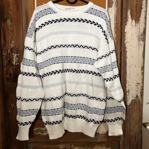 Vit och blå mönstrad stickad tröja - Säljer en mysig vit stickad tröja med blå mönster. Säljer då den är lite för stor för mig och inte kommer till användning Den är både stilren och bekväm, inga defekter. Skriv för fler bilder 💕