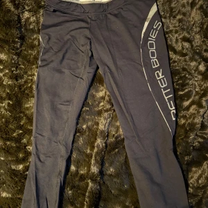 Svarta träningsleggings från Better Bodies - Snygga svarta träningsleggings från Better Bodies med grå detaljer och logga längs benet. Perfekta för gymmet eller löprundan. 