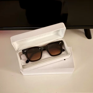  CHIMI 04 Brown  - Snygga bruna solglasögon från CHIMI med en klassisk fyrkantig form. De har en stilren design med mörka glas och en robust båge. Perfekta för att ge en cool touch till din stil.