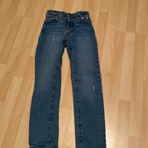 Blå jeans från Levi's - Snygga blå jeans från Levi's med klassisk design och fem fickor. De har en straight passform och är perfekta för en avslappnad stil. Märkeslappen syns tydligt på baksidan. Perfekta för dig som gillar tidlös denim! Passar perfekt för killar i tolv års åldern 