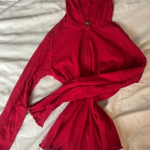 Röd träningströja med dragkedja - Säljer en snygg röd hoodie med dragkedja. Den har långa ärmar och en praktisk huva. Perfekt för en avslappnad stil. Passar bra till jeans eller leggings. Mycket bra för träning, passar de flesta i storleken 