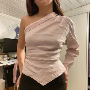 Ljusrosa oneshoulder topp från Zara - Säljer en ljusrosa oneshoulder topp från Zara ❤️ Bara använd till ett tillfälle ⭐️