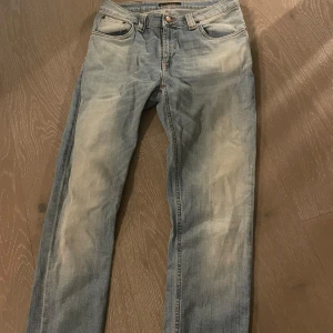 Nudie 30/32 - Snygga blå jeansbyxor med en klassisk femficksdesign och knappgylf. De har en lätt tvättad look och raka ben. Perfekta för en avslappnad stil.