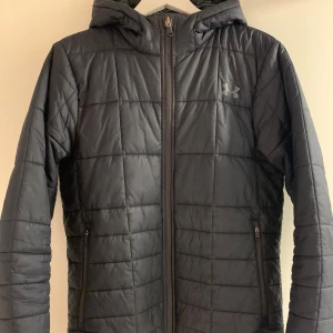Under Armour Jacka - Säljer en svart jacka från Under Armour med dragkedja och huva. Jackan är designad för att hålla dig varm med ColdGear-teknologi. Storlek S/M