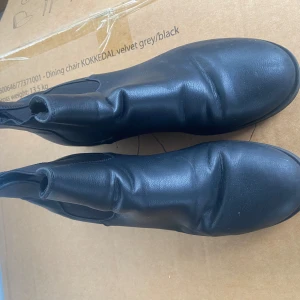 Svarta chelsea boots i skinn - Snygga svarta chelsea boots i skinn med elastiska paneler på sidorna för enkel på- och avtagning. Skorna har en robust sula med bra grepp, perfekt för både stad och natur. 