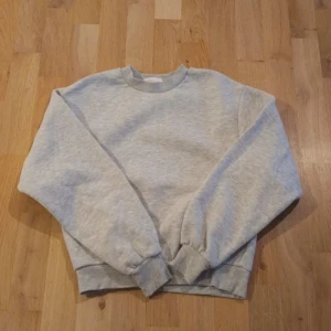 Grå sweatshirt från Gina Tricot - Säljer en klassisk grå sweatshirt från Gina Tricot. Den har en rund halsringning och långa ärmar med ribbade muddar vid ärmslut och nederkant. Perfekt för en avslappnad stil. 🩶 storlek xxs