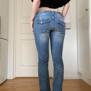 Y2k low waist bootcut jeans - 2000tals jeans med suupelåg midja, klassiska 2000tals fickor fram och fickor med ”lappar” baktill!! Lite bootcut i benen! Jag på bilden har vanligtvis s/m o är 1,65 lång! Midja 39cm innerben 80cm
