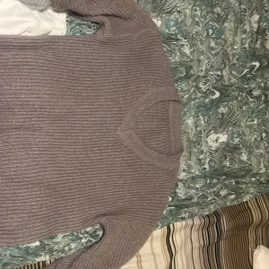 Grå stickad tröja - Mysig grå stickad tröja med v-ringning. Perfekt för kyligare dagar och ger en avslappnad look. Tröjan har långa ärmar och en loose passform som gör den bekväm att bära.den är oversight 