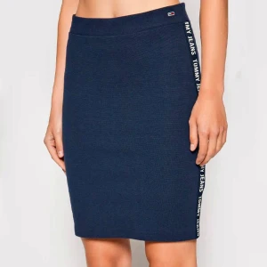 Mörkblå kjol från Tommy Jeans - Snygg mörkblå kjol från Tommy Jeans med logotyp längs sidan. Kjolen har en tight passform och är perfekt för en stilren look. Nyskick.