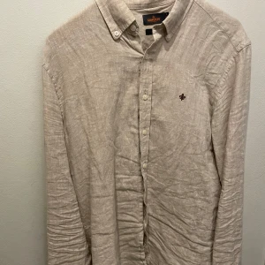 Beige linneskjorta från Morris - Säljer en stilren beige skjorta från Morris i 100% linne. Mycket bra skick. Hör av er vid funderingar.