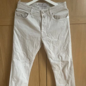 Beige jeans från Jacob Cohën - Snygga jeans från Jacob Cohën med klassisk femficksdesign och knappgylf. Perfekta för en stilren look. Tillverkade med italienskt hantverk för extra komfort. Storleken sitter som w30-31. Bara att fråga om ni undrar något!