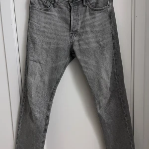 Grå jeans från Jack & Jones - Snygga grå jeans från Jack & Jones i modellen Relaxed/Chris. De har en avslappnad passform och klassisk femficksdesign. Perfekta för en casual look.