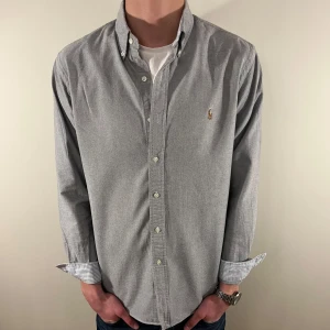 Grå Ralph Lauren skjorta - Nu säljer vi ännu en fet polo skjorta som passar till alla tillställningar och skjortan är i mycket bra skick! Du ska kunna uttrycka stil utan att det kostar för mycket!🕺🍾💼🤩  Storlek👔: L Nypris💰: ca 1499 kr