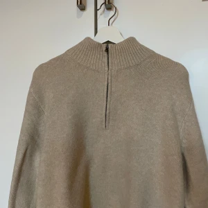 Beige stickad tröja quarterzip - Säljer en beige stickad quarterzip från uniqlo i storlek M. Gjord i ull. I princip aldrig använd!