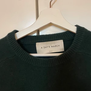 Mörkgrön stickad tröja från A Day's March - Säljer en mörkgrön stickad tröja i 100% ull från A days march i storlek M. Knappt använd!