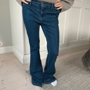 Blå bootcut jeans - Snygga blå bootcut jeans med lopppg midja  Perfekta för en avslappnad stil. Klassisk design med dragkedja och knapp framtill. Lite slitna i bak men inget som märks! Annars bra skick