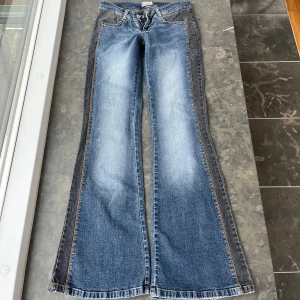 Lågmidjade Bootcut jeans  - Snygga blå bootcut jeans med cool detalj på sidan. Innerbensläng:79 cm och midjemått rakt över: 33