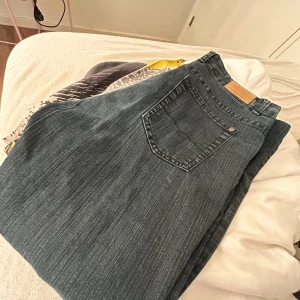 Mörkblå/svarta  jeans från ZeZe Jeans. - Snygga mörkblå/svarta  jeans från ZeZe Jeans med klassisk femficksdesign och knappgylf. Perfekta för en avslappnad stil. Märkeslogga synlig vid linningen. 