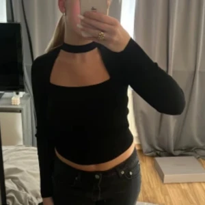 Svart choker tröja - Snygg svart långärmad topp med unik design. Perfekt för en trendig look. Passar bra till både jeans och kjol.